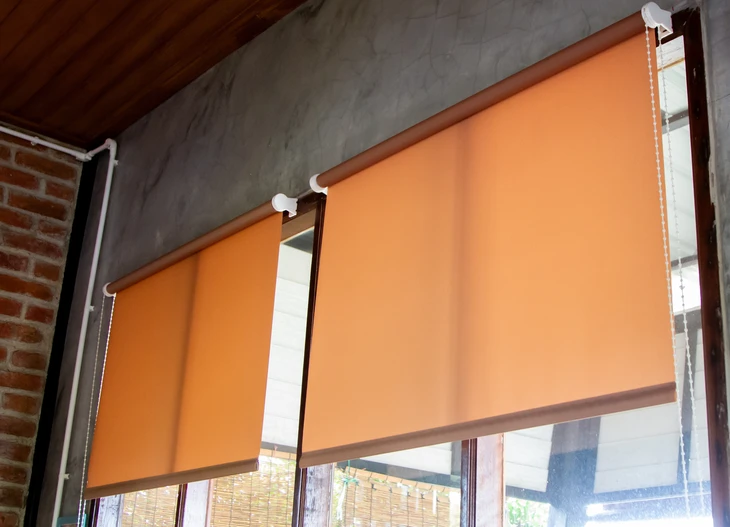 Jeune femme blonde souriante essayant une robe de mariée blanche dans un magasin spécialisé, entourée de robes suspendues sur portants