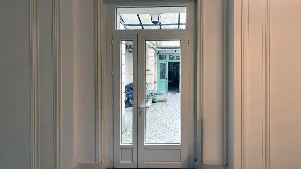 Entrée moderne d'habitation avec porte d'entrée en bois clair équipée de baies vitrées latérales