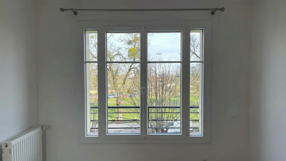 Vue de l'immeuble avec de grandes fenêtres et des volets à rouleaux noirs à l'extérieur