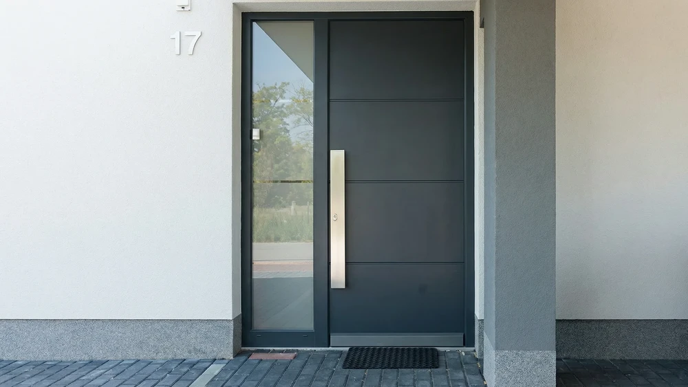 Entrée résidentielle moderne avec escalier en béton, porte d'entrée contemporaine beige à insert vertical lumineux