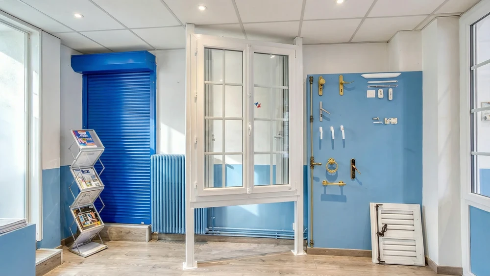 Fa&ccedil;ade ext&eacute;rieure r&eacute;sidentielle avec porte d'entr&eacute;e verte &agrave; panneaux et encadrement blanc, flanqu&eacute;e de deux fen&ecirc;tres sym&eacute;triques &agrave; volets battants verts