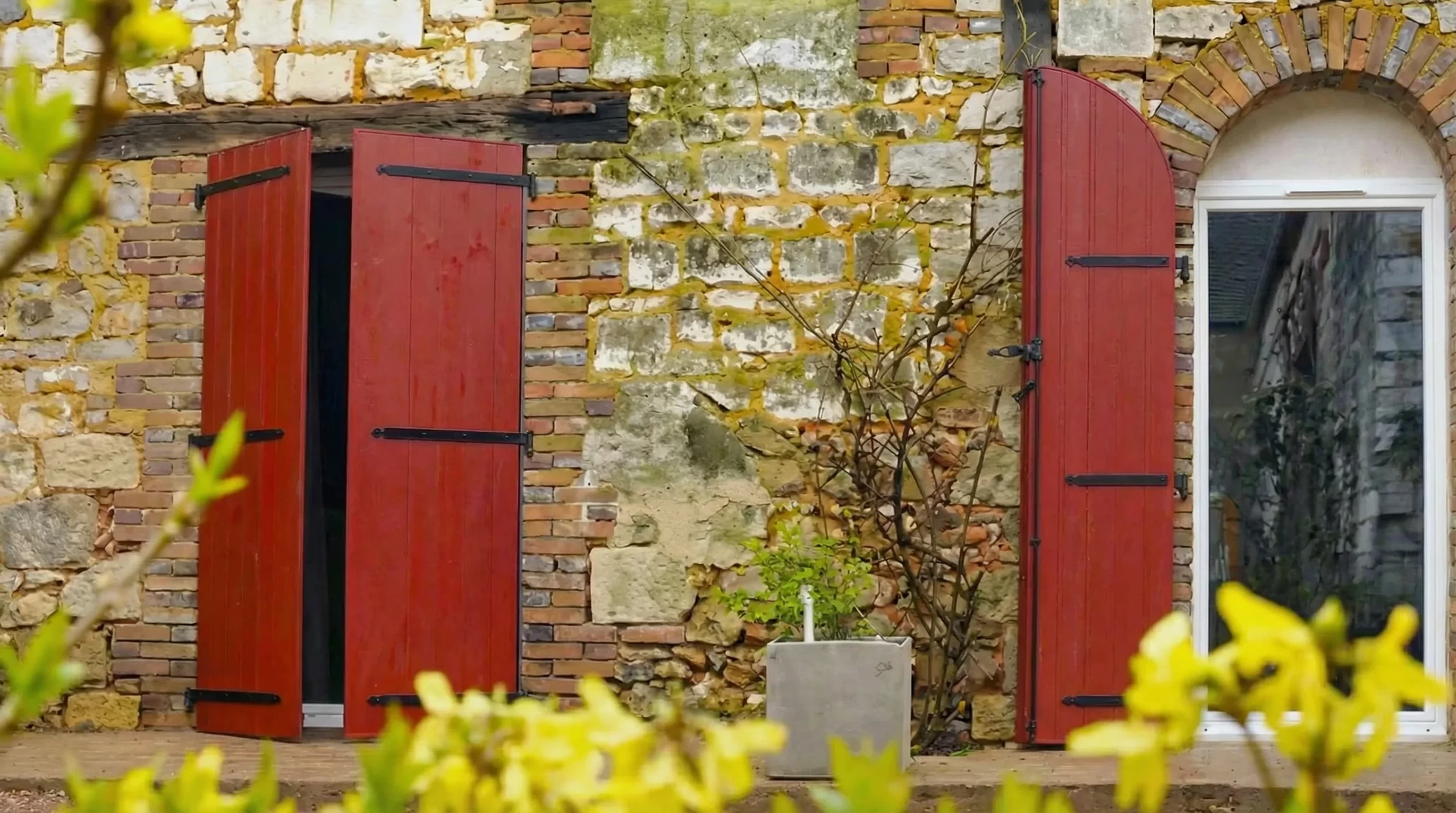 Entrée moderne d'une maison contemporaine avec porte d'entrée grise et panneau latéral vitré