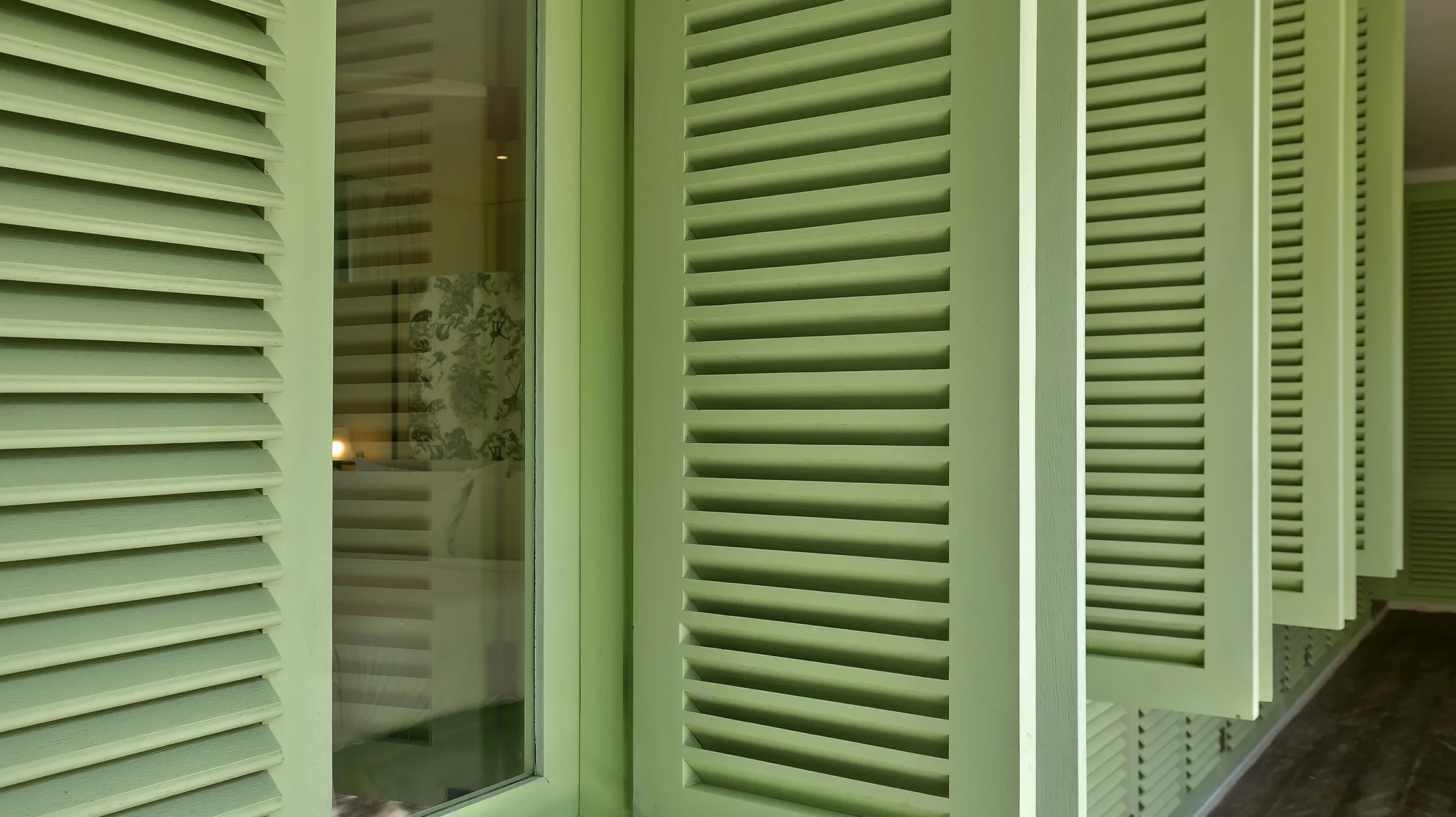 Artisan menuisier barbu en tablier de cuir et chemise à carreaux dans son atelier de menuiserie